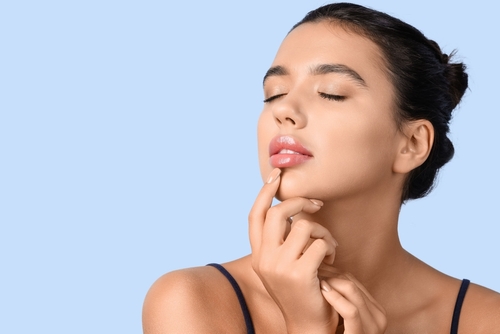 Young,Woman,With,Beautiful,Lips,On,Blue,Background,,Closeup Lip Filler Liverpool